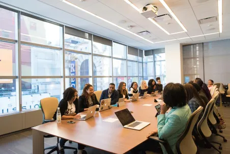 Group of people at an office meeting discussing a successful change management process for the company.