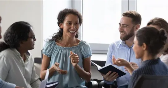 A group of people sit in a circle talking.