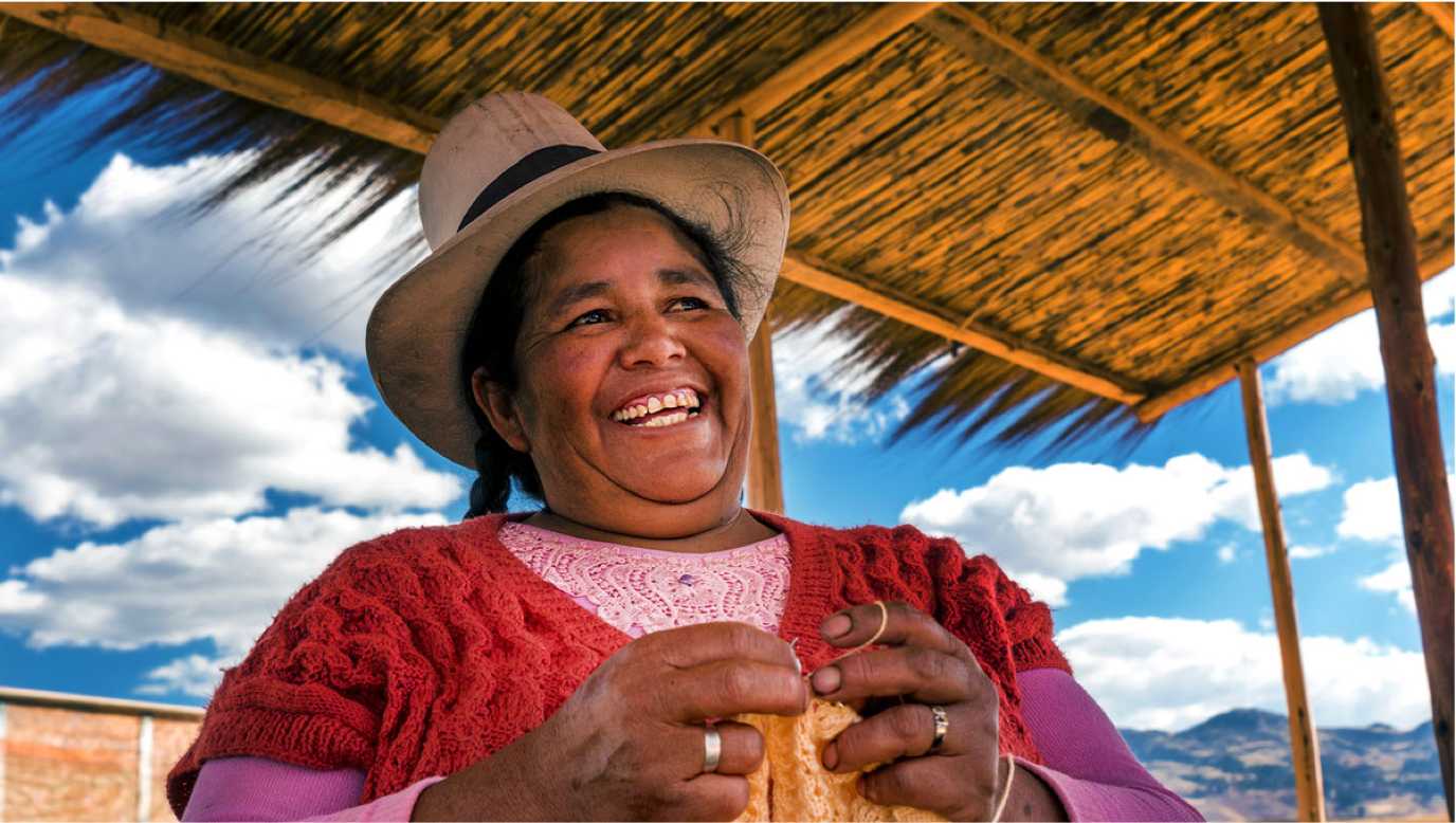 Woman laughing in an open air hut.