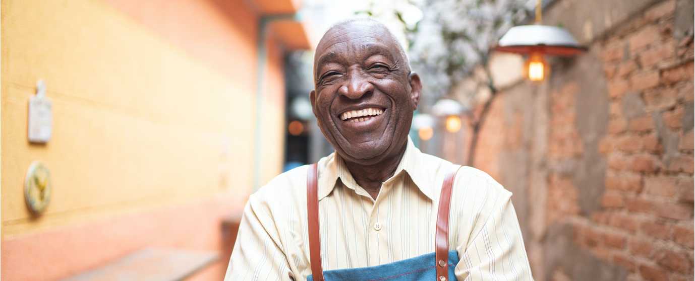 older gentleman artisan laughing with arms crossed