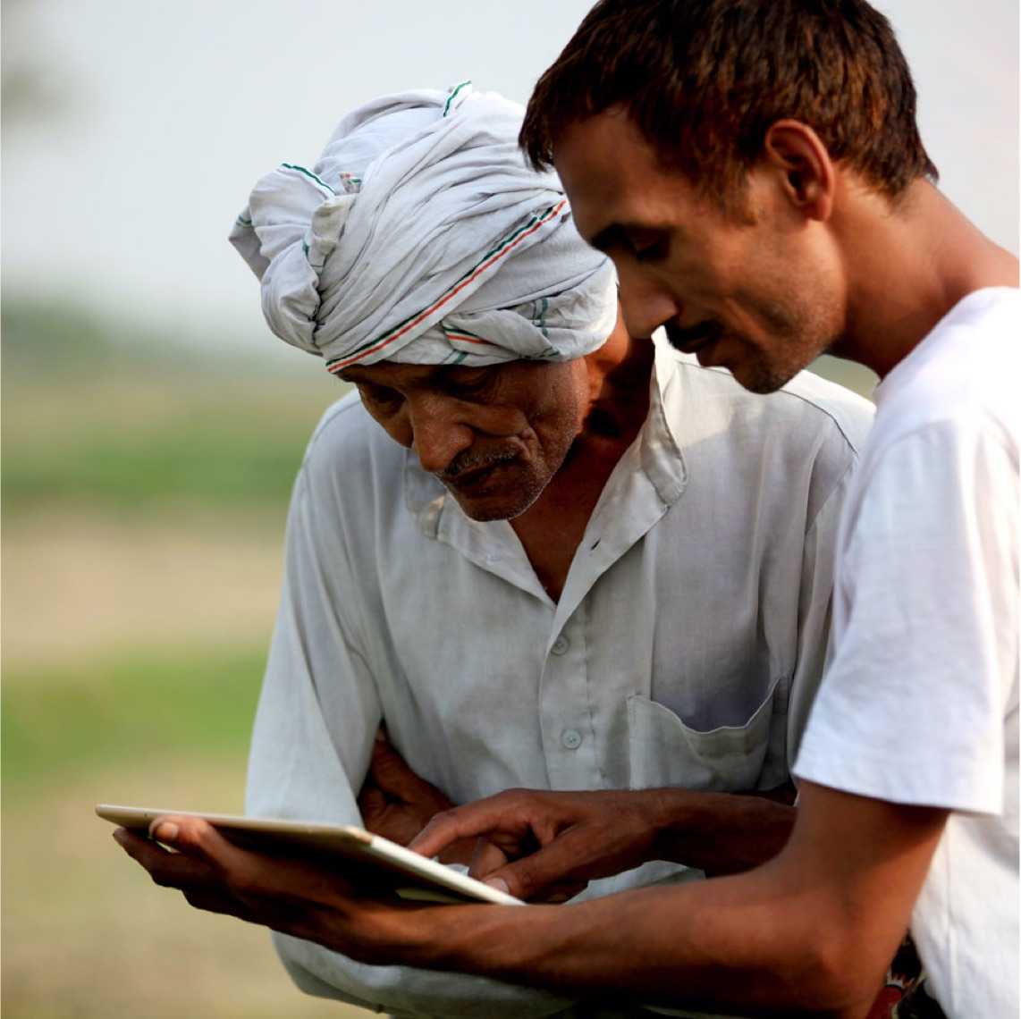 an older gentleman and younger man working with a tablet computer